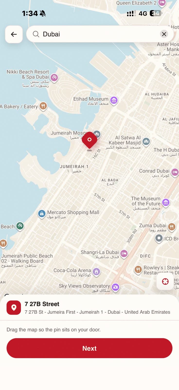 Map address picker centred on Jumeirah 1 in Dubai, with a dropped pin and the confirmed street address in a bottom sheet